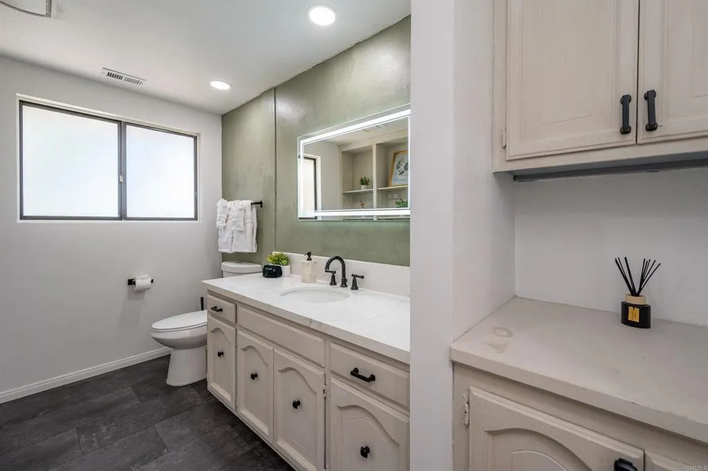 26086 Bear Valley Heights Road Valley Center, CA 92082 - Photo 38 of 65 a bathroom with a toilet sink and mirror