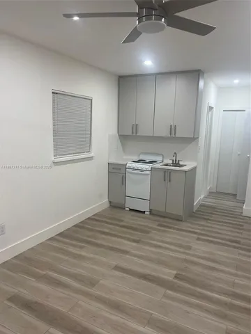 a view of a kitchen with a sink and a refrigerator