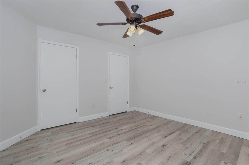 633 Buoy Lane, Unit 104 Altamonte Springs, FL 32714 - Photo 12 of 16 an empty room with wooden floor and a ceiling fan
