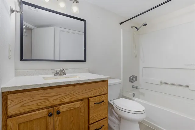a bathroom with a sink toilet vanity and tub