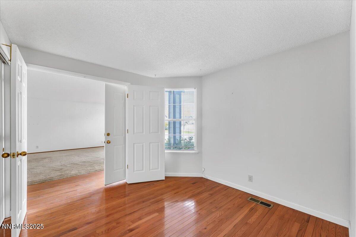 4434 Whitney Circle Sparks, NV 89436 - Photo 24 of 32 an empty room with wooden floor and windows