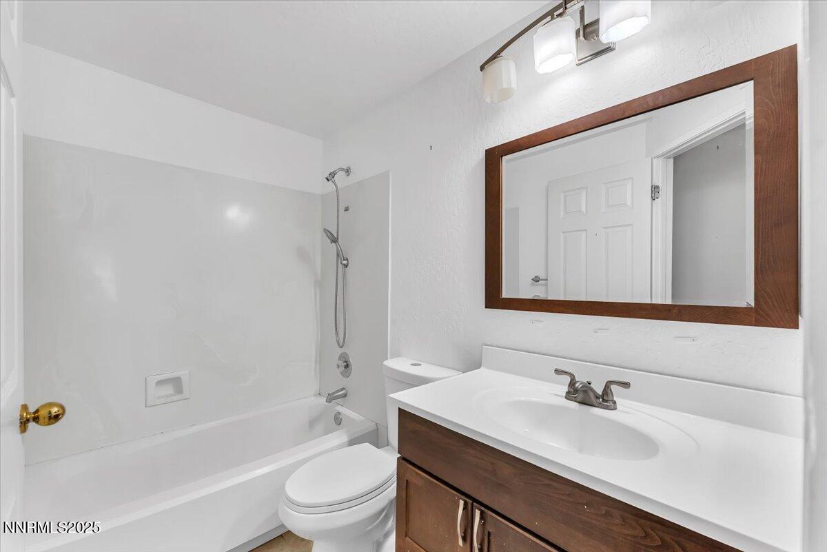 4434 Whitney Circle Sparks, NV 89436 - Photo 25 of 32 a bathroom with a granite countertop sink toilet a mirror and shower