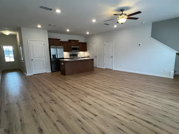 a kitchen with stainless steel appliances granite countertop a sink a stove a refrigerator a washer dryer and white cabinets