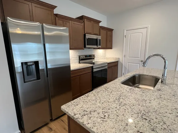a kitchen with a sink and wooden floor