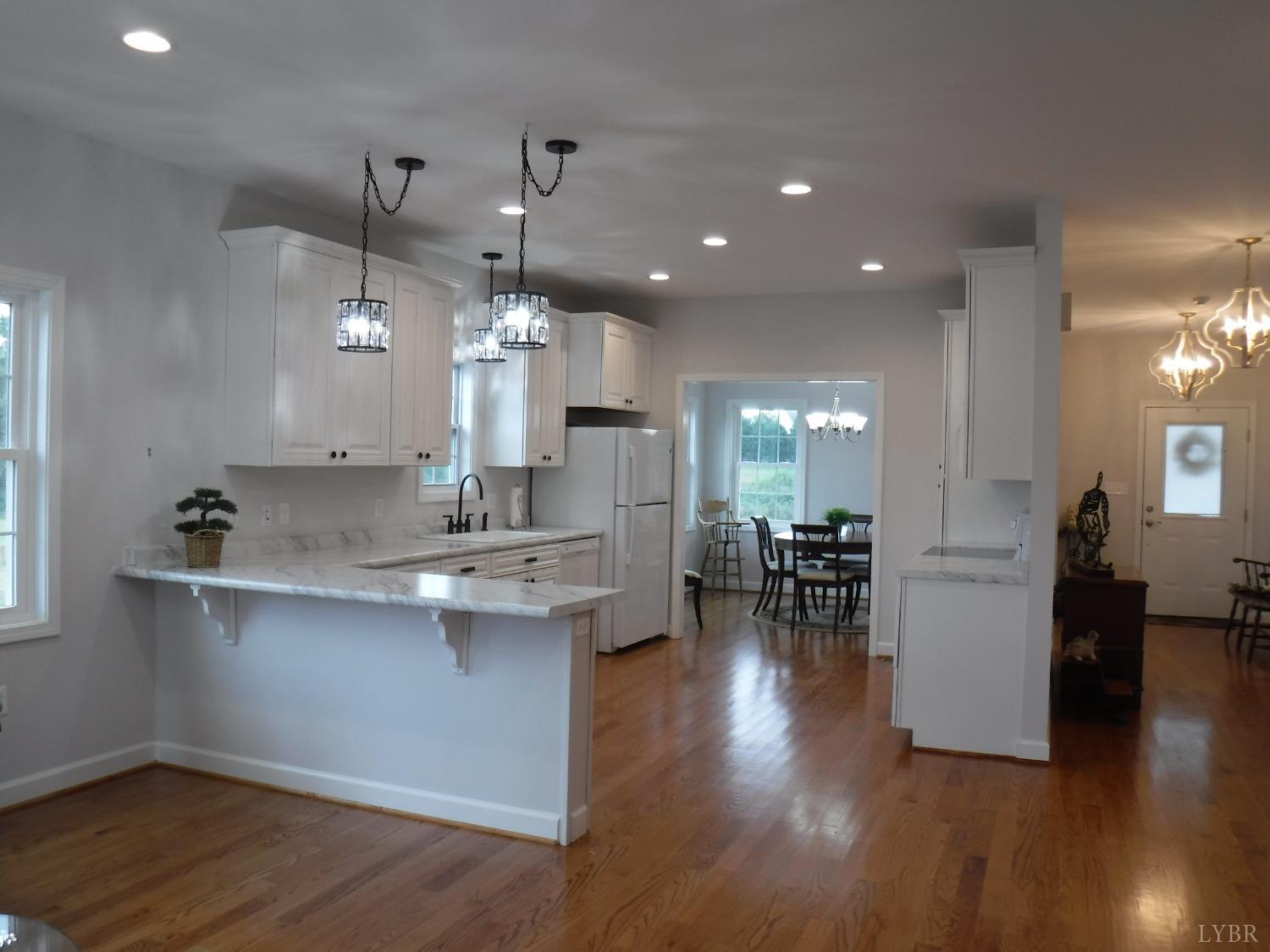 203 Longhill Road Goode, VA 24556 - Photo 22 of 26 a kitchen with counter space dining table and wooden floor