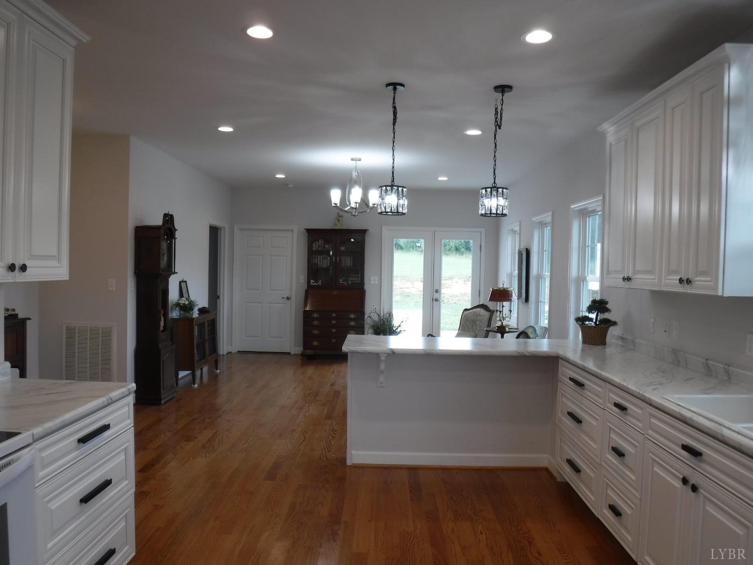 203 Longhill Road Goode, VA 24556 - Photo 23 of 26 a kitchen with stainless steel appliances kitchen island granite countertop a refrigerator a stove and a wooden floors