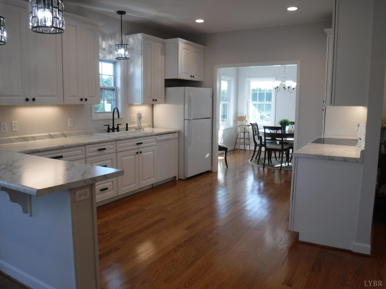203 Longhill Road Goode, VA 24556 - Photo 25 of 26 an open kitchen with wooden floor and stainless steel appliances