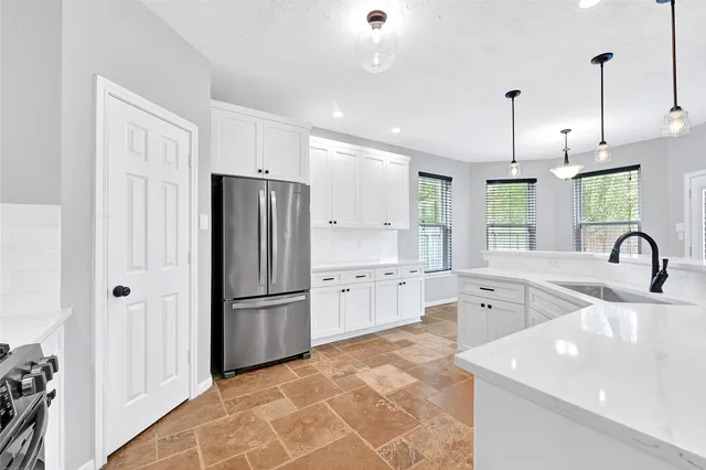 a kitchen with stainless steel appliances granite countertop a refrigerator a sink dishwasher a stove and a refrigerator with wooden floor