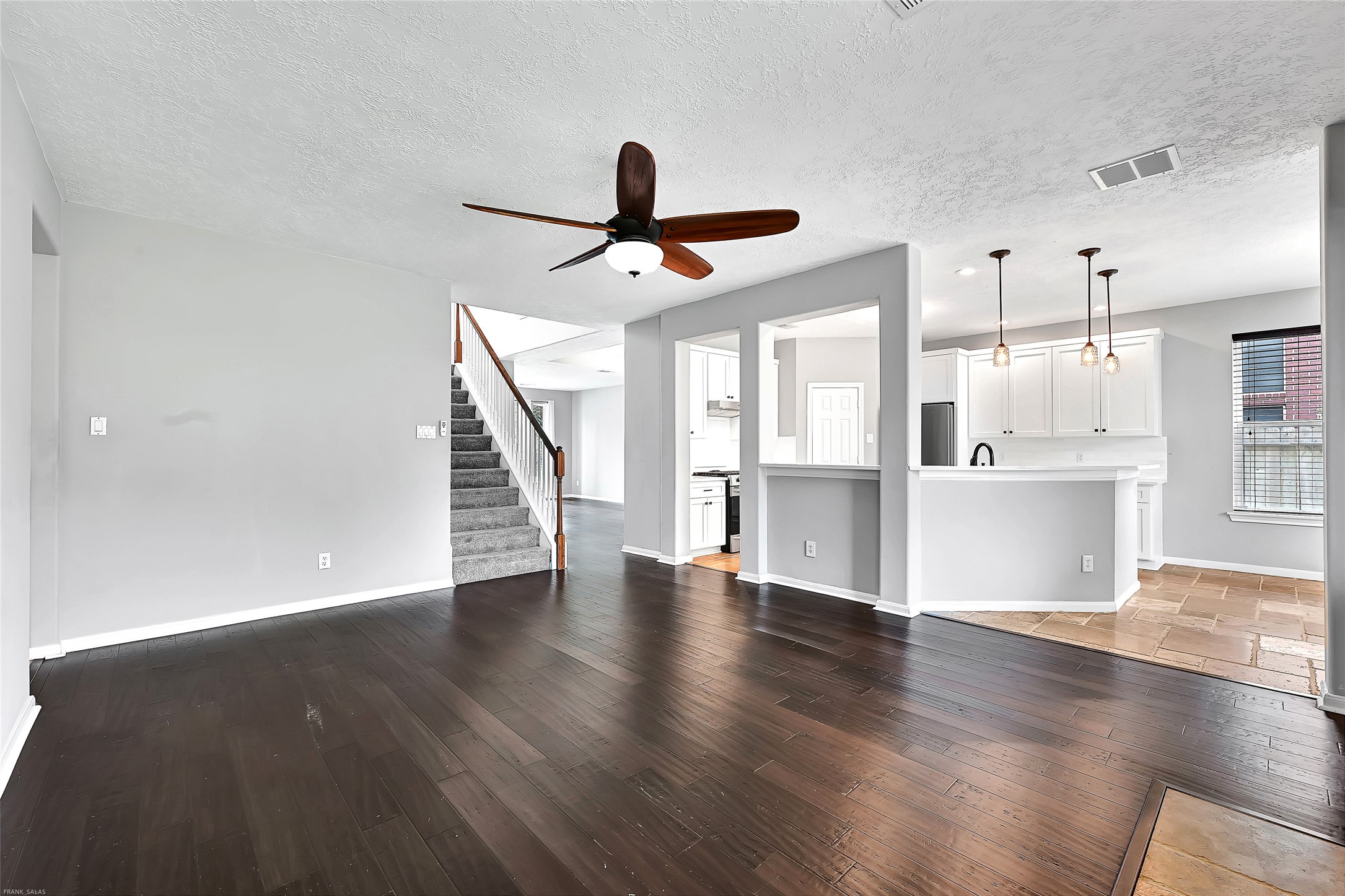 10219 Sable Trail Lane Houston, TX 77064 - Photo 9 of 31 a view of an empty room with wooden floor and a kitchen