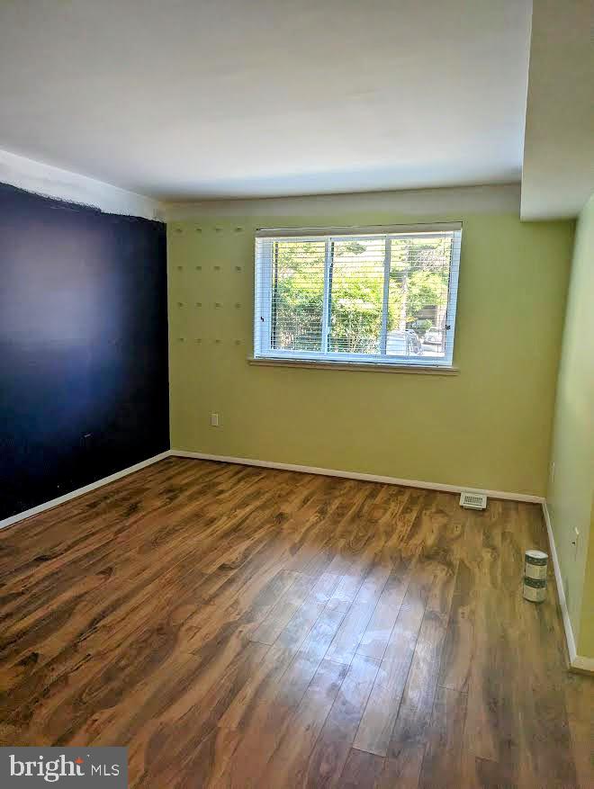 1621 Parkcrest Circle, Unit 101 Reston, VA 20190 - Photo 12 of 16 a view of an empty room with wooden floor and a window