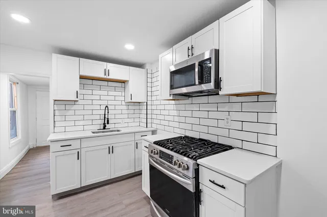 a kitchen with stainless steel appliances a sink stove and microwave