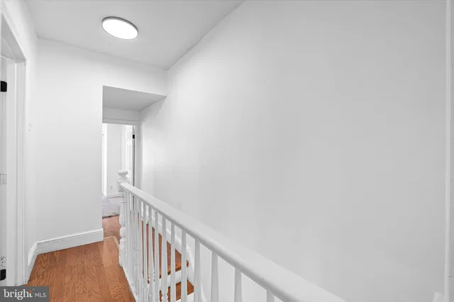 a view of a hallway with wooden floor and entryway