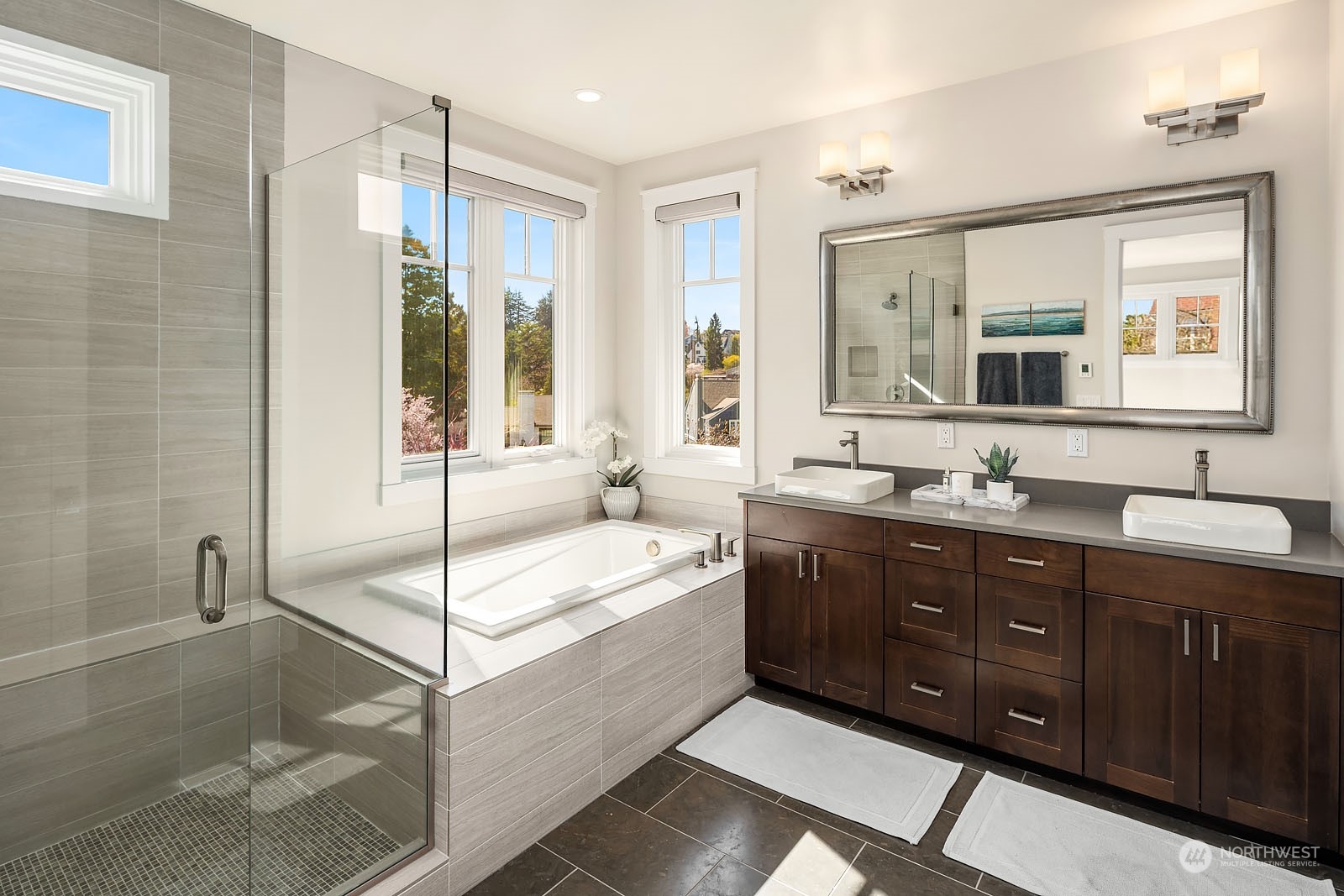 5108 Northeast 42nd Street Seattle, WA 98105 - Photo 17 of 40 a spacious bathroom with double vanity a sink a mirror a bathtub and next to a window
