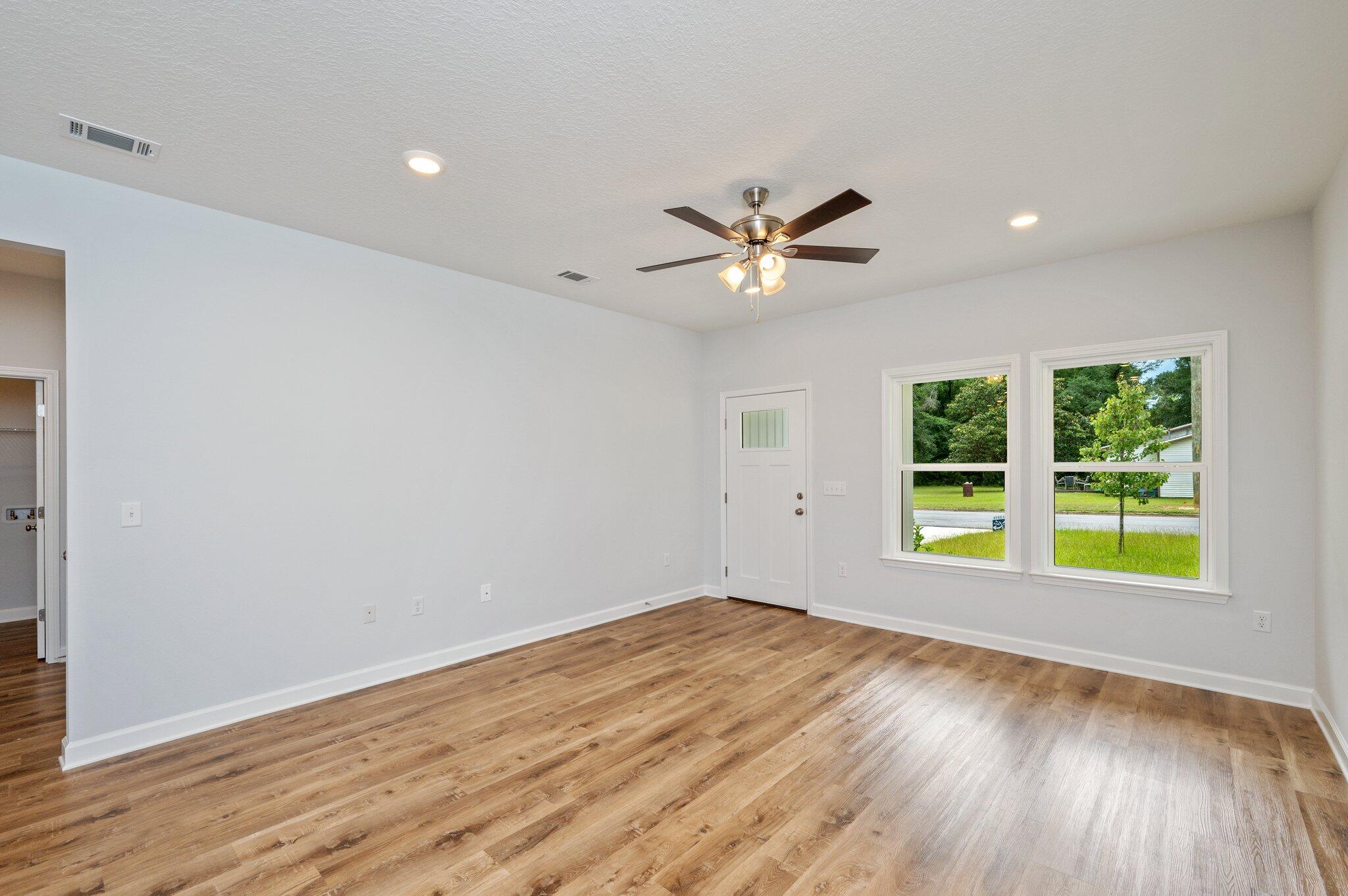 858 South Rayburn Street Crestview, FL 32539 - Photo 4 of 29 an empty room with wooden floor and windows