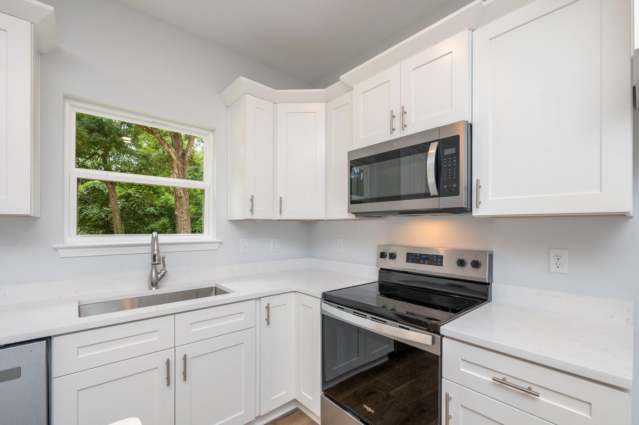 858 South Rayburn Street Crestview, FL 32539 - Photo 9 of 29 a kitchen with stainless steel appliances a sink a stove a microwave and cabinets