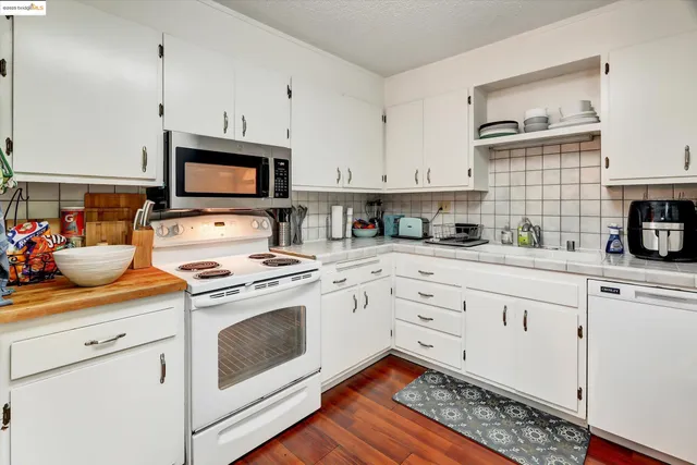 a kitchen with cabinets appliances a sink and a counter top space