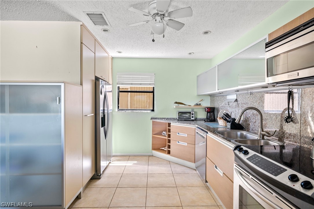 5117 Sea Bell Road, Unit B208 Sanibel, FL 33957 - Photo 3 of 25 a kitchen with stainless steel appliances a sink a stove and cabinets