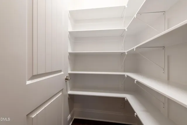 a kitchen with stainless steel appliances granite countertop a sink a stove a refrigerator and white cabinets with wooden floor