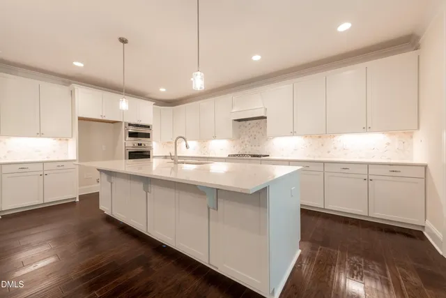 a large kitchen with stainless steel appliances granite countertop a sink stove and refrigerator