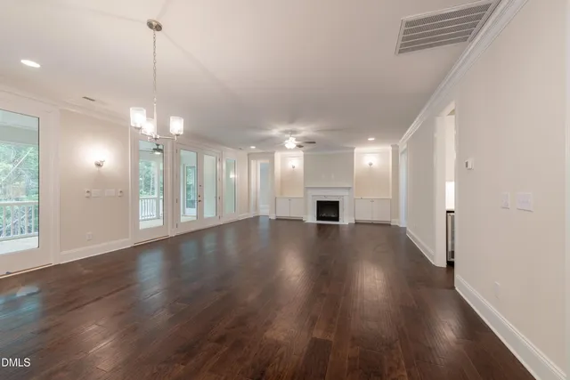 a view of a hallway with wooden floor and a kitchen