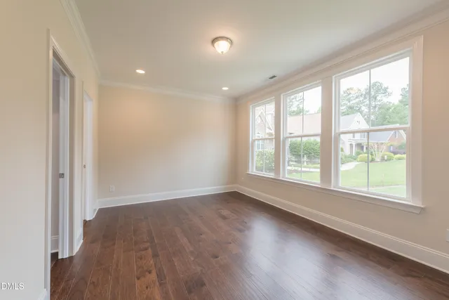 an empty room with windows and chandelier fan