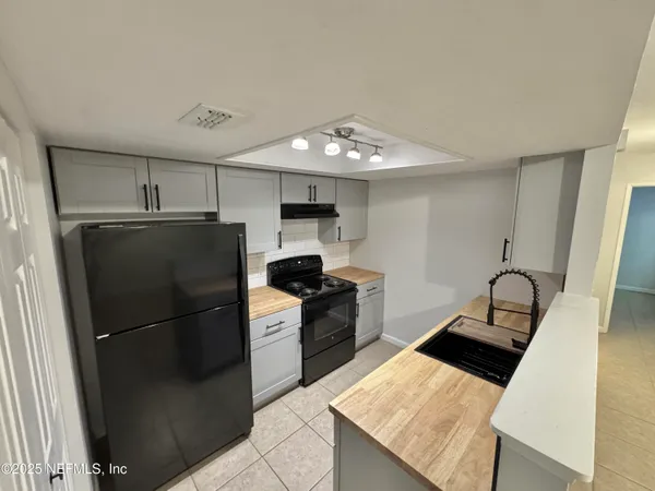 a kitchen with granite countertop a refrigerator stove and sink