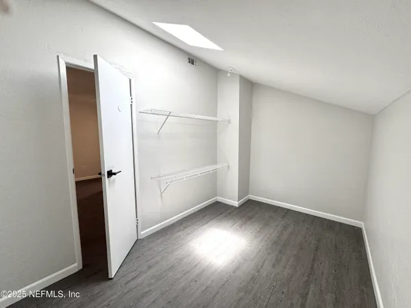 an empty room with wooden floor and white walls