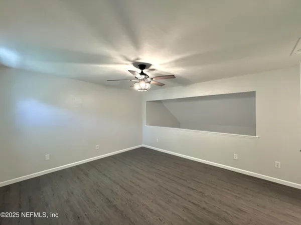 a view of a room with wooden floor and fan