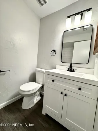 a bathroom with a toilet sink and mirror