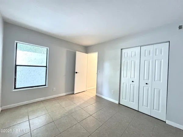 an empty room with windows and closet