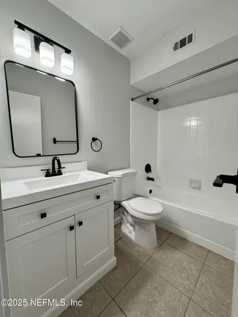 a bathroom with a toilet a sink a mirror and bathtub