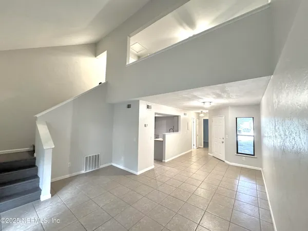 a view of a hallway with wooden floor and a living room