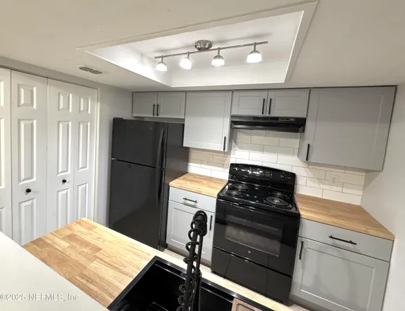 a kitchen with a refrigerator stove and cabinets