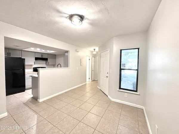 a view of a kitchen with a sink and a refrigerator