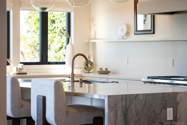 a large white kitchen with a large window