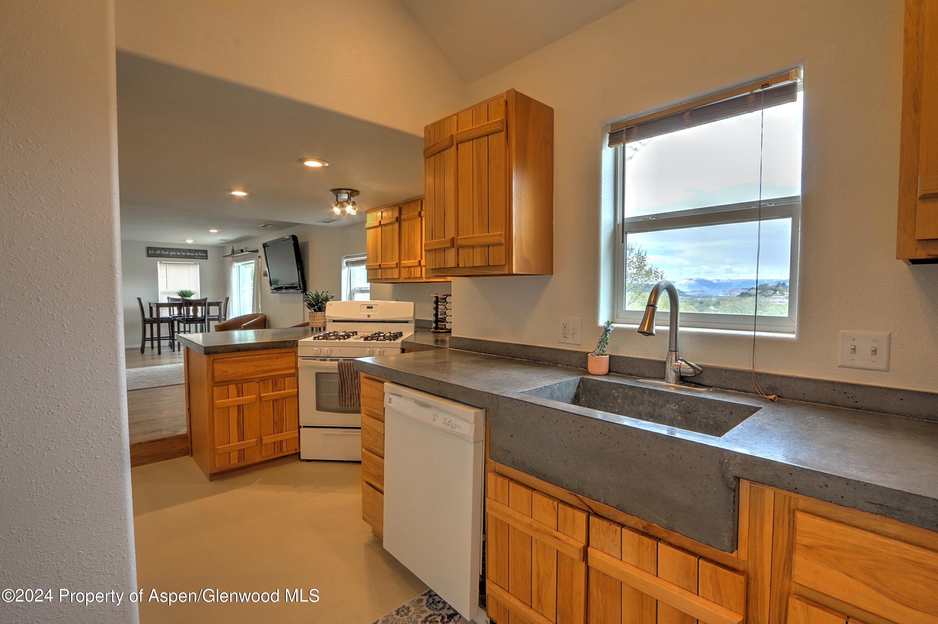 412 East 4th Street Rifle, CO 81650 - Photo 6 of 18 a kitchen with stainless steel appliances granite countertop a sink a stove and a refrigerator