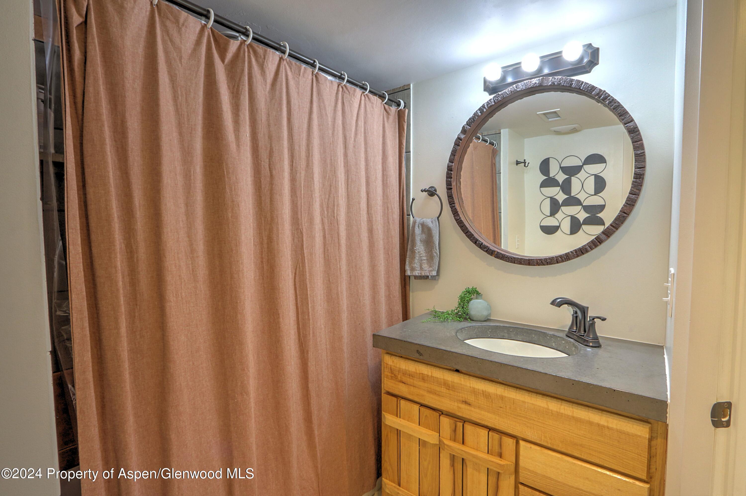 412 East 4th Street Rifle, CO 81650 - Photo 10 of 18 a bathroom with a sink and a mirror