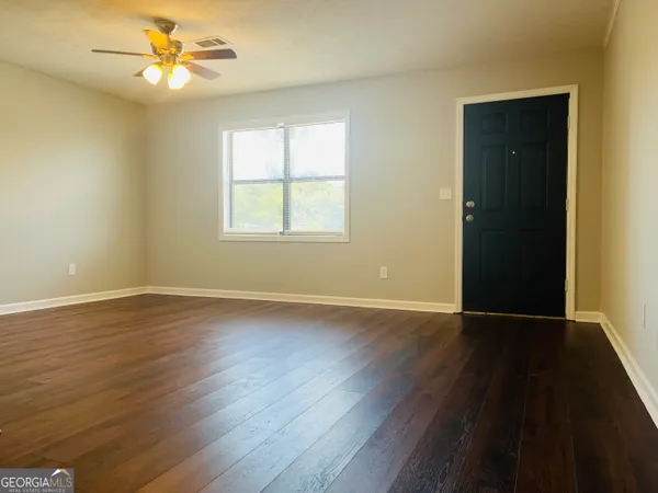 a view of an ocean & kitchen with wooden floor and fan