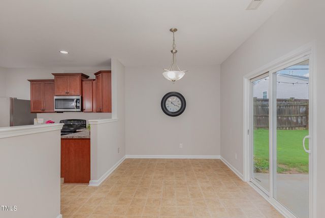 a view of a kitchen with a stove fridge wooden floor and a window