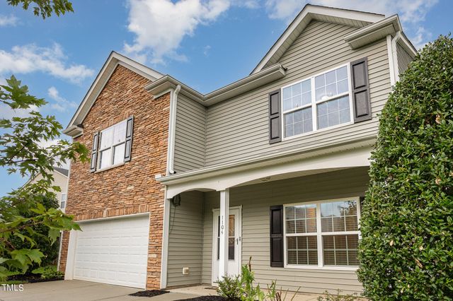 a view of a house with a yard and a large tree