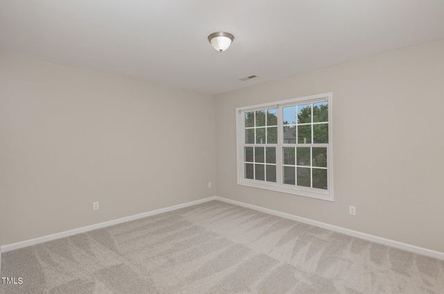 a view of an empty room with window and bathroom