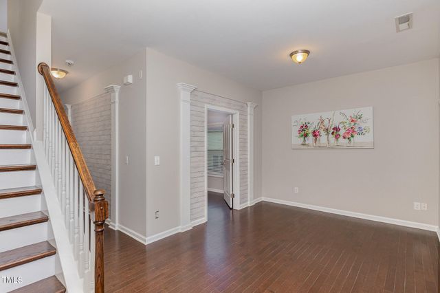 a view of a hallway with wooden floor and stairs