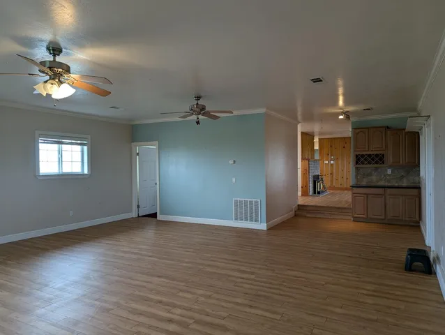 a view of a kitchen and an empty room with a kitchen