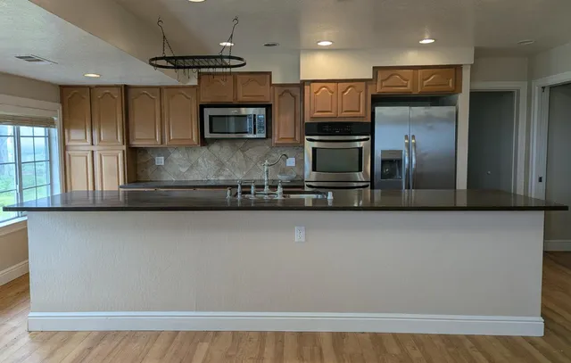 a kitchen with stainless steel appliances a refrigerator a stove top oven a sink and dishwasher