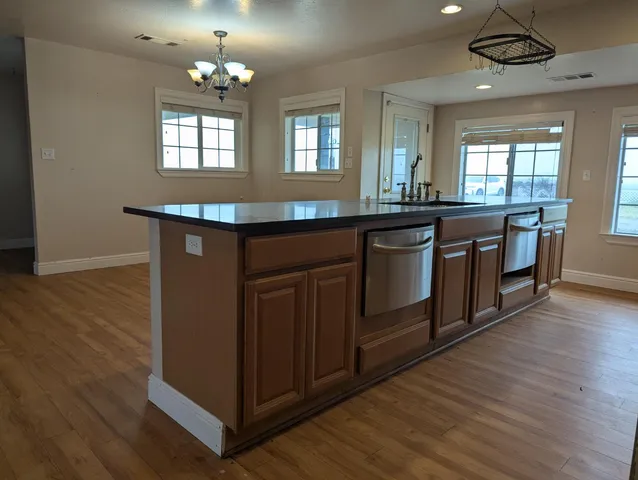a kitchen with stainless steel appliances granite countertop stove top oven and cabinets