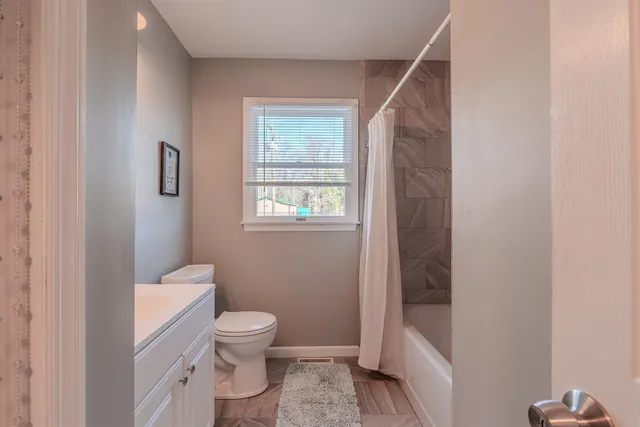 a bathroom with a toilet a sink and shower