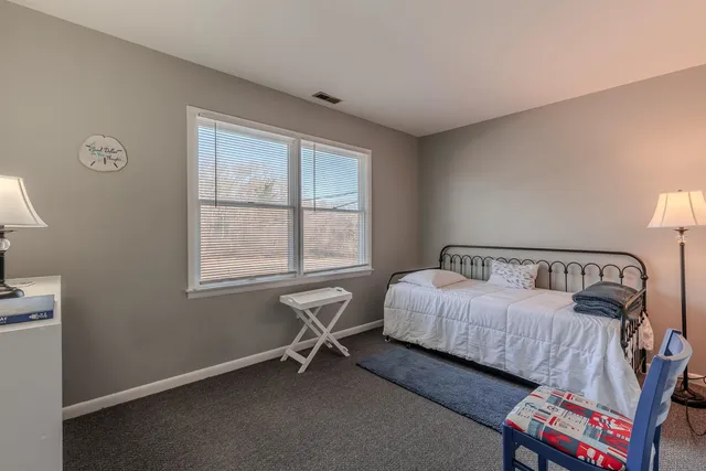 a bedroom with a bed and a table in it with window