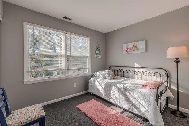 a spacious bedroom with a bed and a chandelier