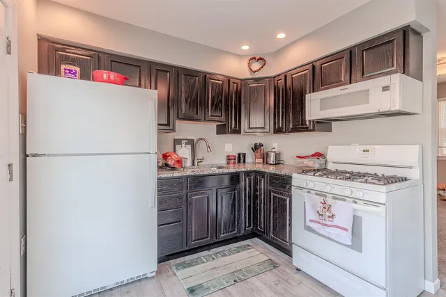 a kitchen with stainless steel appliances granite countertop a refrigerator and a sink