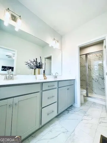 a spacious bathroom with double sink and mirror
